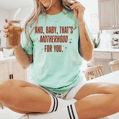 mom holding ice coffee wearing graphic shirt inspired by showgirl era, taylor swift