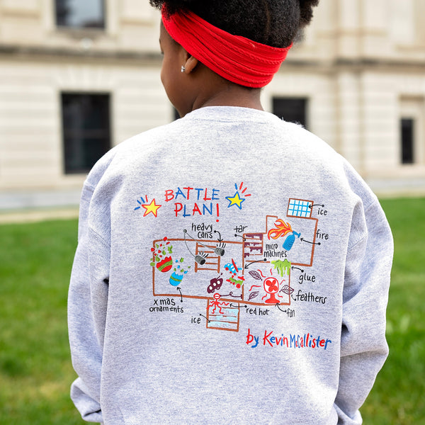 christmas themed holiday sweatshirt shows kevins battle plan from home alone with an embroidered design of a house on the front.