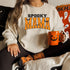 sweatshirt with halloween decorations and jackolanter mug with screen print that says spooky mama for halloween season
