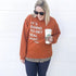 blonde woman in plus size wearing pumpkin orange sweatshirt layered with leopard print shirt and leggings holding starbucks coffee with text on the sweatshirt saying its going to get real basic, fall pullover