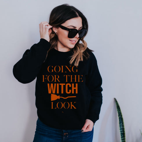 black sweatshirt or pullover with orange text halloween theme design that says going for the witch look