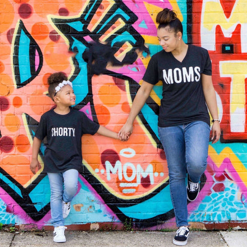 mom and daughter wearing matching shirts in front of graffiti wall for a cute mommy and me set