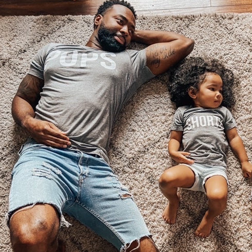 girl dad shirt, dad and daughger laying on the floor posing for pops and shorty shirts in heather grey design girl dad toddler matching shirts